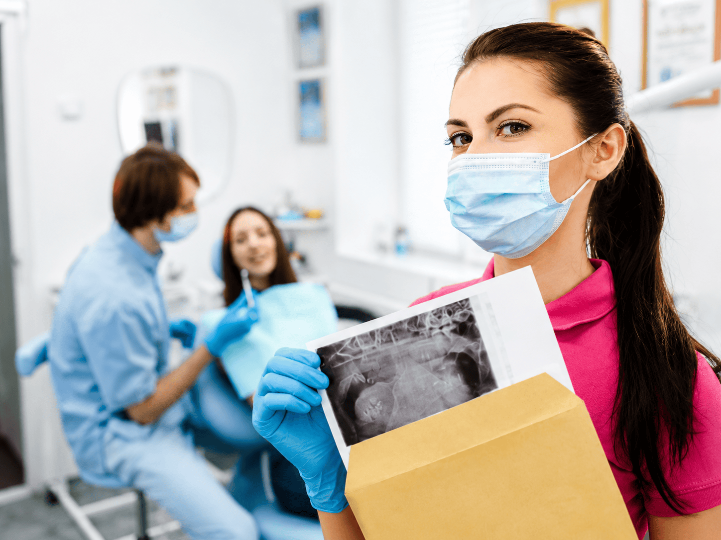 Dentista con immagine a raggi X e paziente in clinica dentistica, che mostra assistenza dentale e consulenza professionale.
