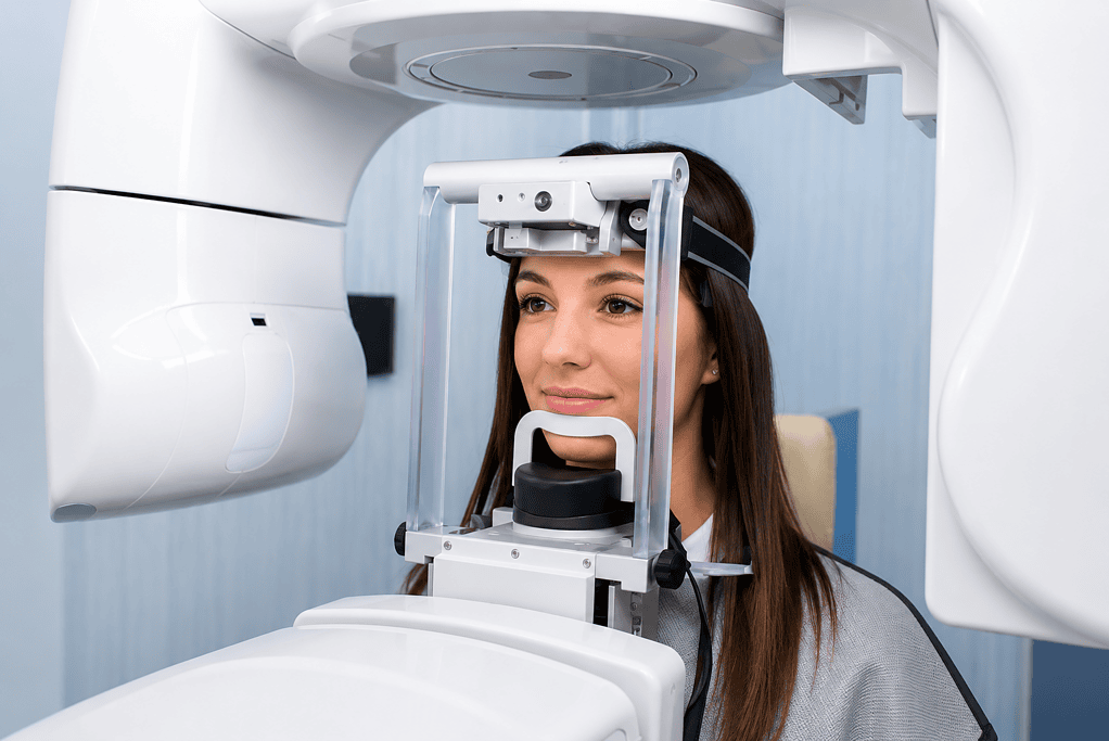 Mujer sometiéndose a una radiografía panorámica dental en una clínica moderna para una evaluación integral de la salud bucal.
