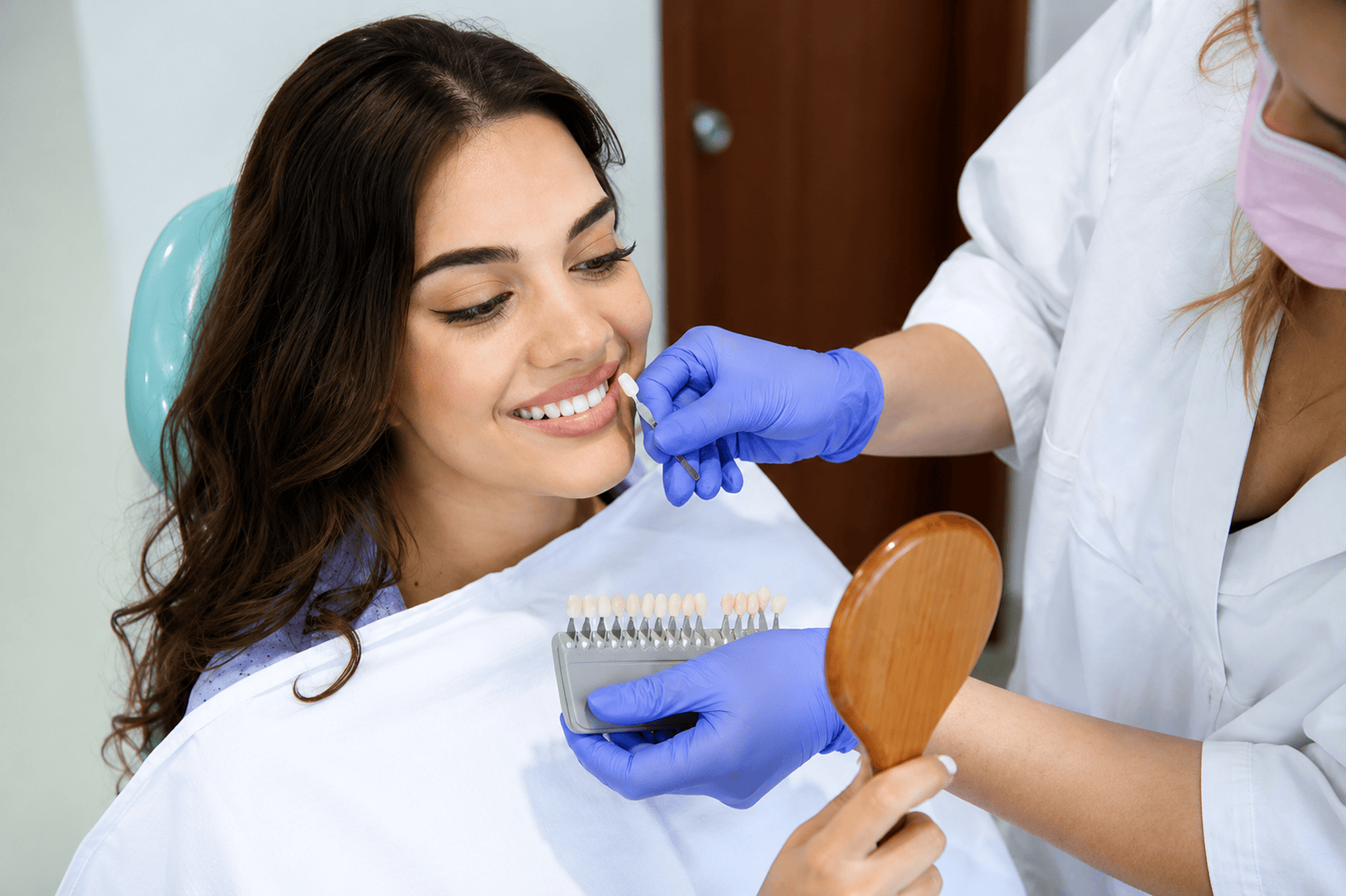 Mujer sonriendo en una clínica dental durante una sesión de igualación del tono dental con un dentista.