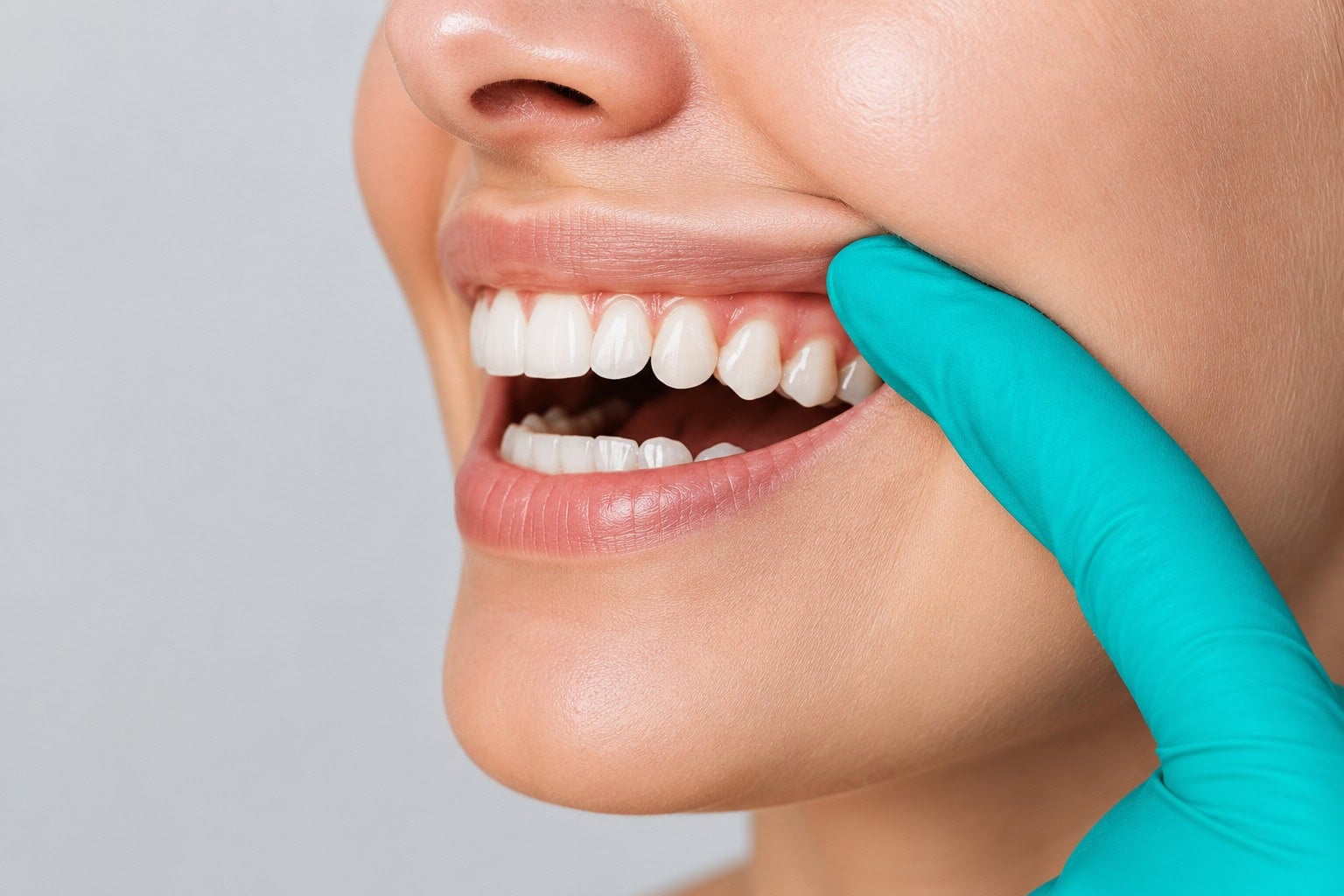 Gros plan d'un dentiste examinant des dents et des gencives saines avec une main gantée, mettant en valeur la santé bucco-dentaire et les soins dentaires.