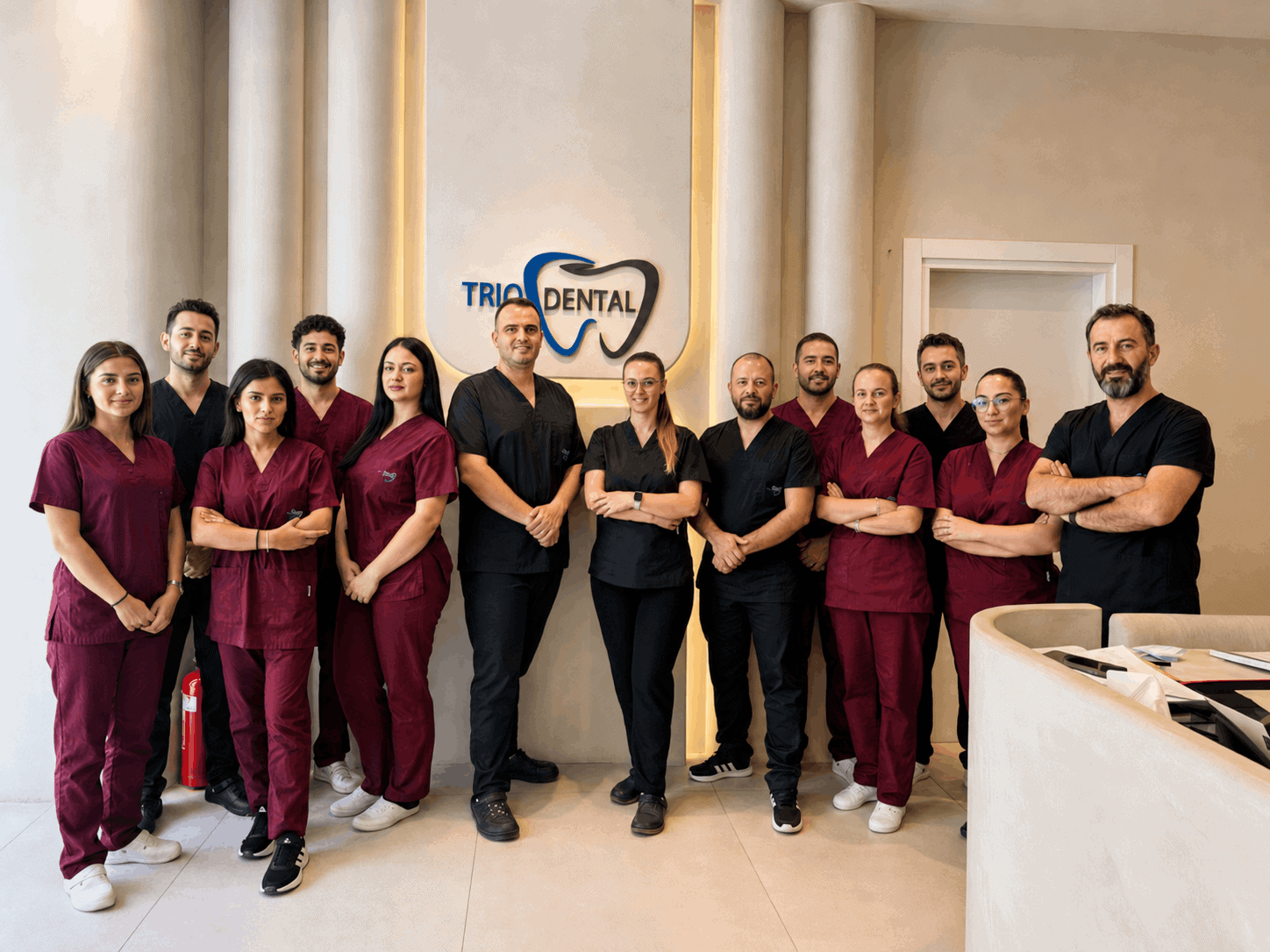 Dental team in uniform standing inside Trio Dental Clinic, showcasing professional staff in a modern clinic setting.