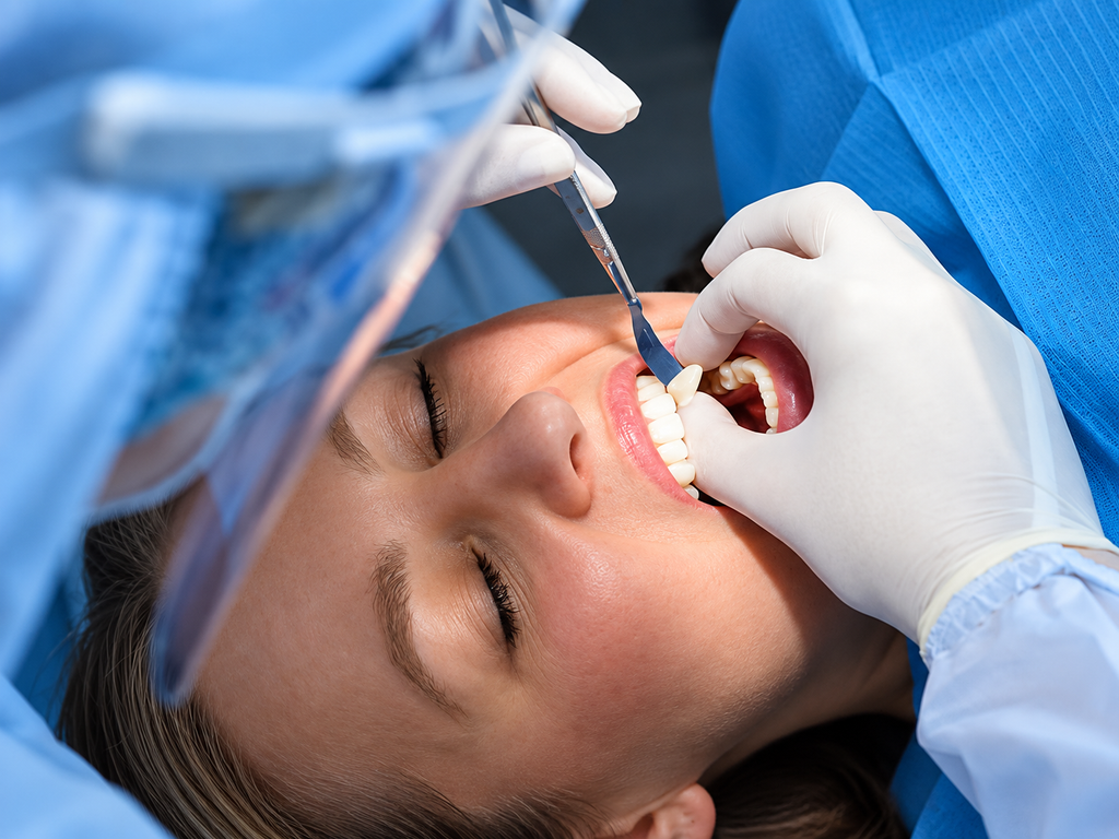 Patient receiving dental care, dentist using tools for oral examination and treatment in clinic.
