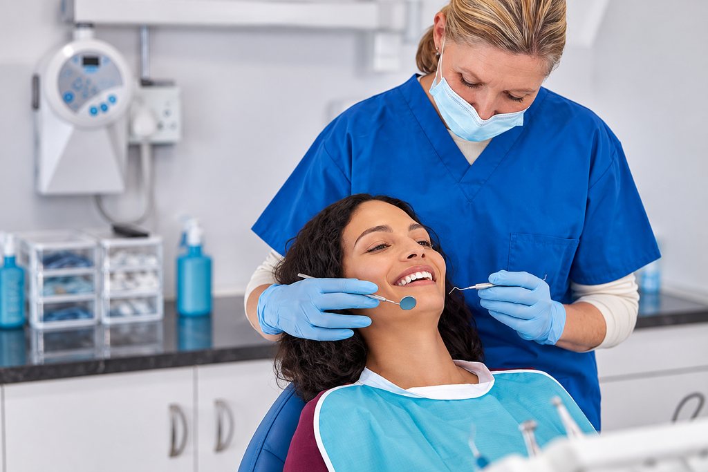 Dentist examining a smiling patient in a dental clinic, ensuring oral health and care.